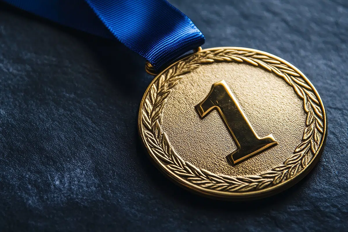 a blue ribbon featuring a golden medal with the numeral one