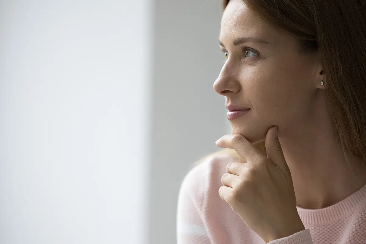 attractive young s woman looks pensive staring into distance