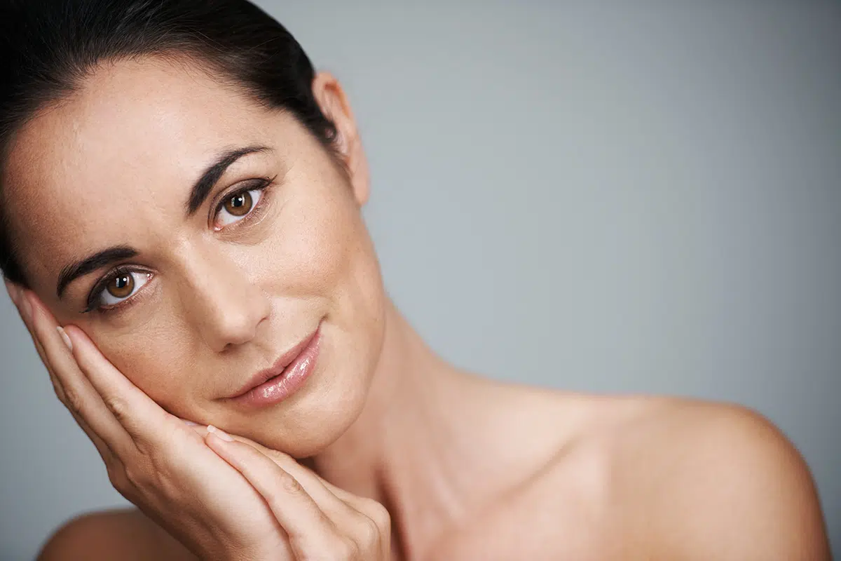 beautiful mid adult woman touching her face