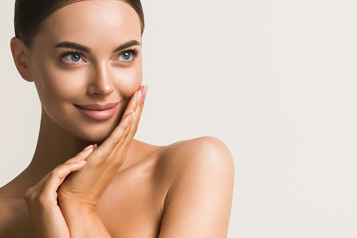 beautiful woman face close up natural make up hand touching face
