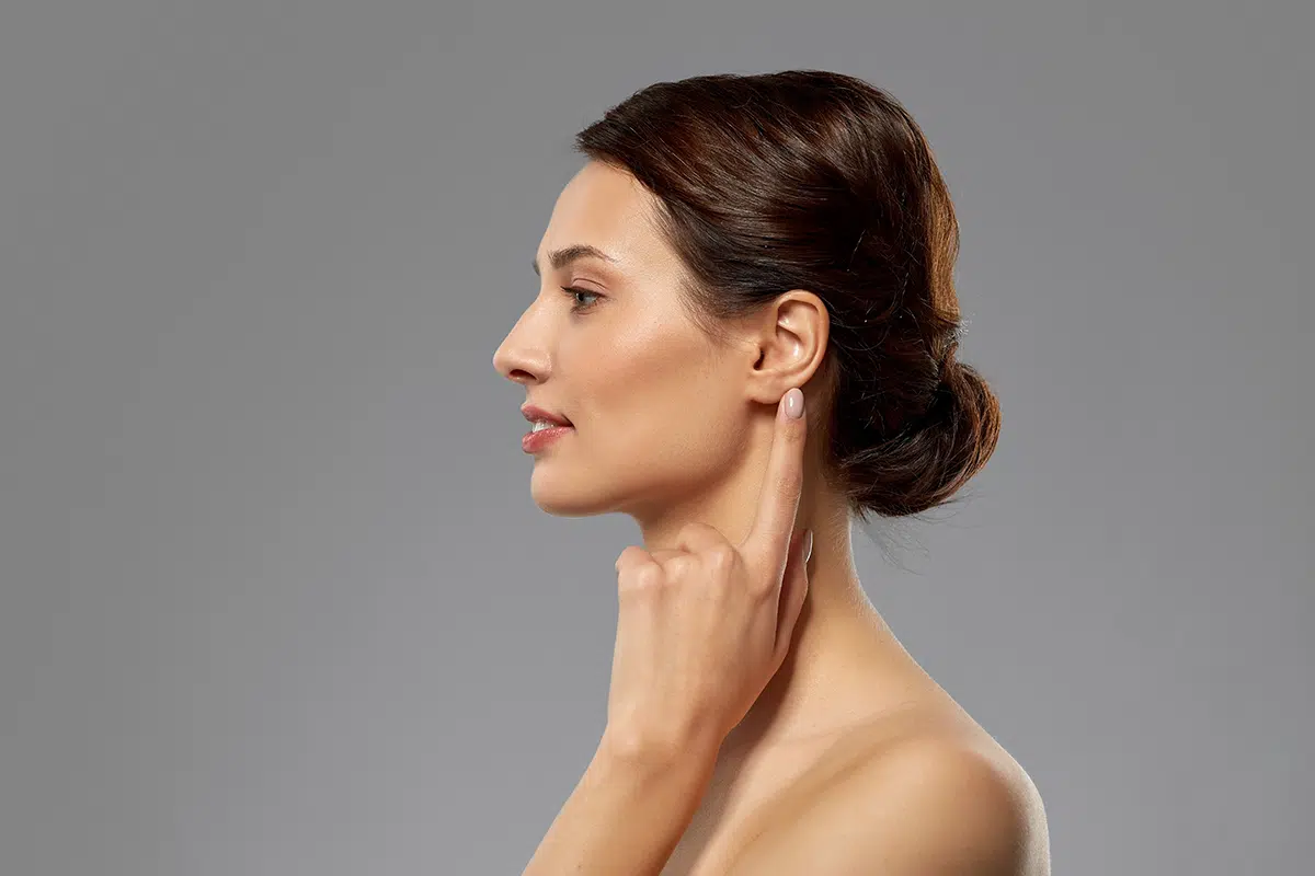 beautiful young woman pointing finger to her ear