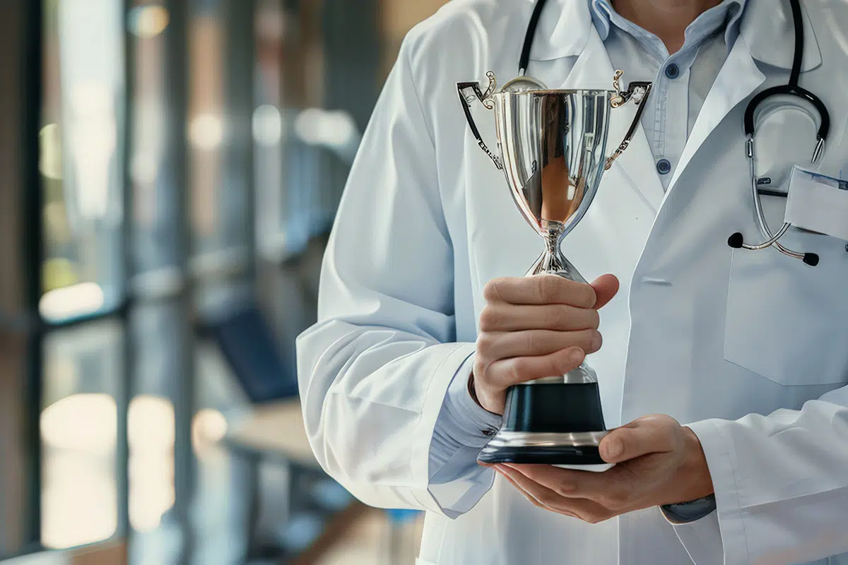 doctor celebrating achievement with trophy in hospital hall