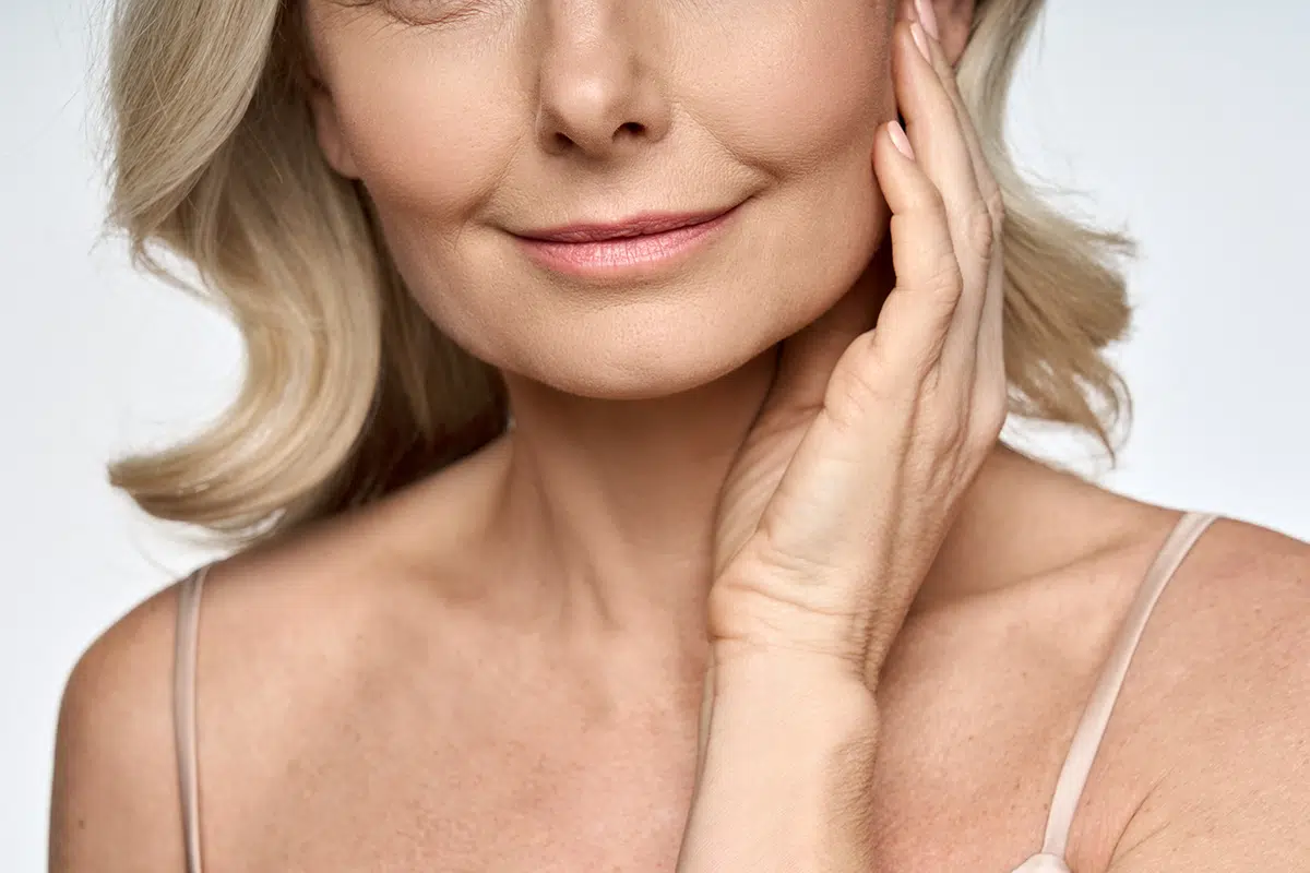 happy mid age years old woman touching face with hand