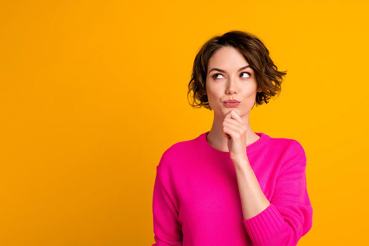 portrait of minded girl touch fingers chin look copyspace think wear pullover