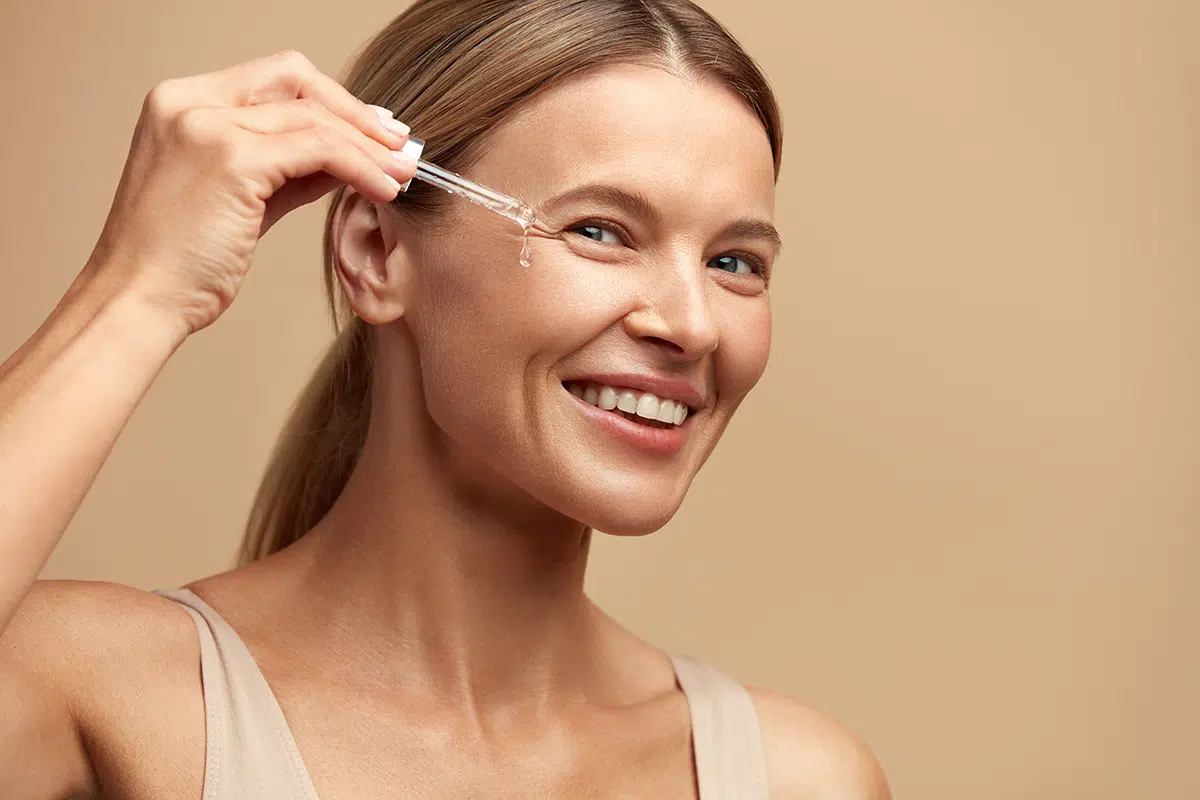 woman dropping serum on face
