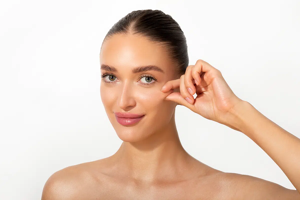 woman touching her cheek and smiling