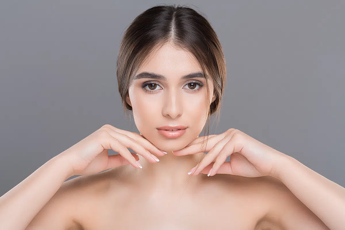 young beautiful woman with perfect skin massaging her face