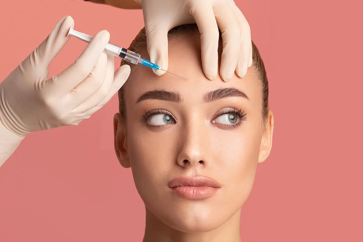 young woman receiving botox beauty injection in her forehead